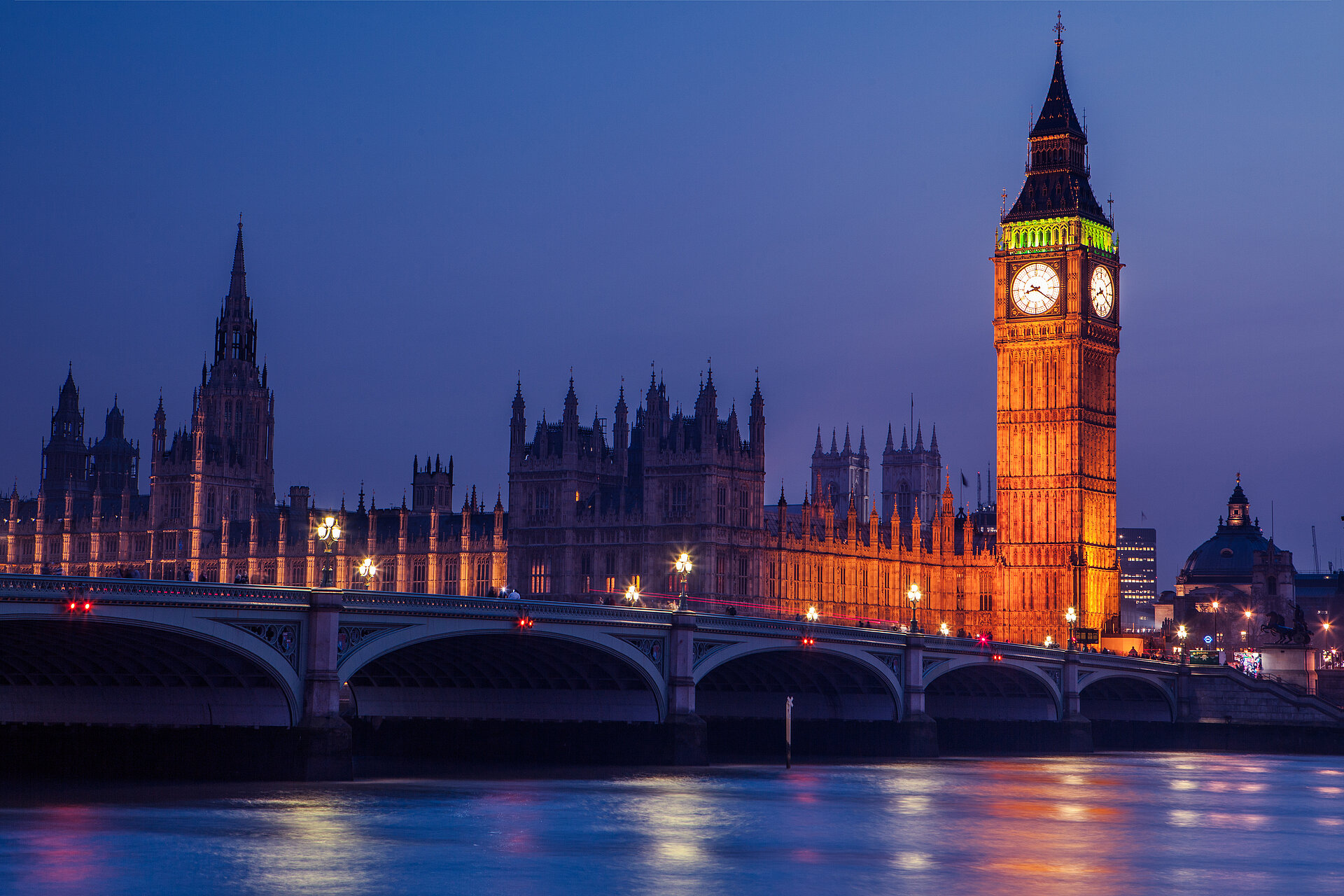 Elizabeth Tower und die Houses of Parliament an der Themse in der Dämmerung.